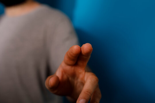 Close up of hand and fingers touching screen on blue background