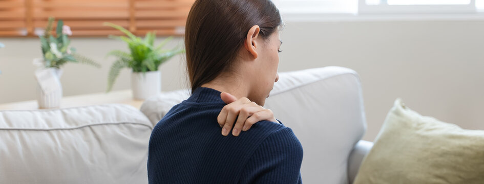Asian woman feeling hurt shoulder and neck muscle problem.