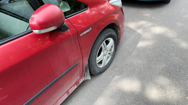 Toyota Prius Hybrid car parked on an urban street, showing vehicle design details and hybrid technology branding