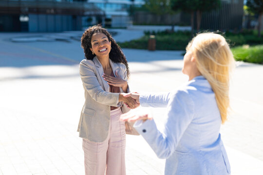 Diverse businesswomen shaking hands confirming partnership