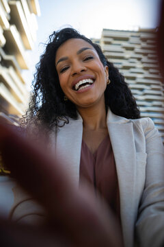 Happy woman recording a video or taking a selfie outdoors