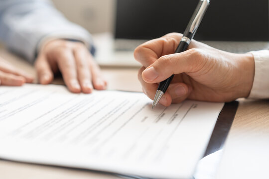 Business people signing contract signature for agreement on papers while customer, partner, coworker holding pen putting signs signature at desk office, one person point to offer letter at desk office