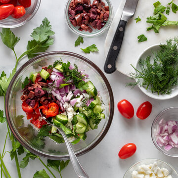 A bowl of fresh cut up vegetables to make a mediterranean salad.