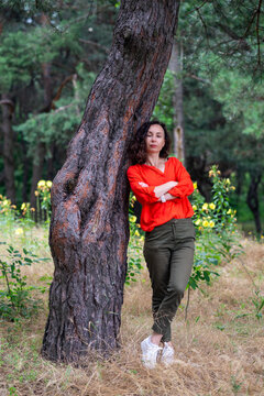 Woman Leaning Against Tree in Park