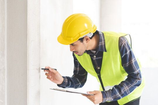 Building inspection asian contractor young man, male inspecting home, reconstructed construction, renovation or check defect, before finish handing it over to client, customer. Engineering worker.