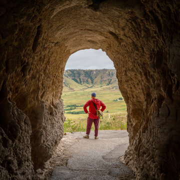 male hiker walking through a tunnel on the Saddle Rock Trail leading to the summit of Scotts Bluff National Monument