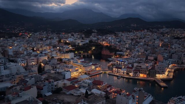 Aerial drone view of the town wrapped around Lake Voulismeni and the harbor, Agios Nikolaos, Greece