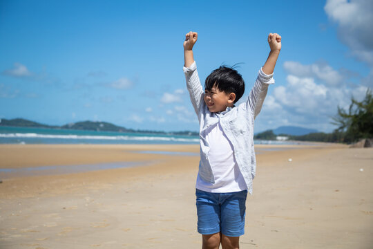 Summer holidays  travel and vacation on the beach. Happy Asian kid smailing and thump up on sand beach.