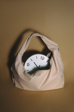 Beige Handbag Containing Clock in Minimalist Fashion Still Life