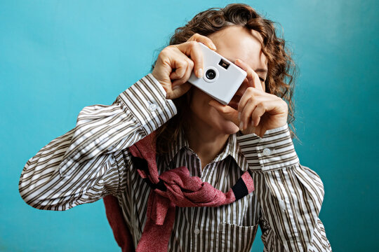 A woman takes a photo with a disposable film camera