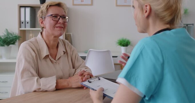 Doctor and nurse during consultation with senior woman. In medical clinic, they share healthcare advice with empathy and support, reviewing treatment options. Healthcare, patient support and trust.