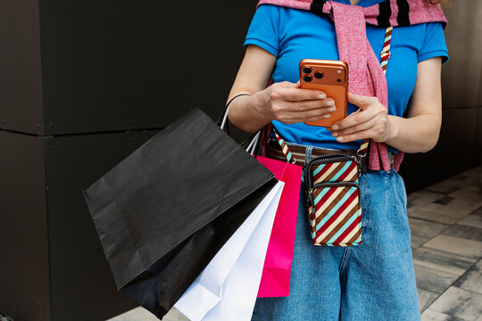 A man with bags and a phone in his hands