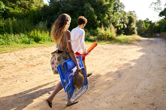 Couple walking sandy path to beach with diabetes sensor
