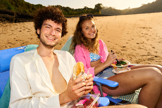 Happy couple enjoying beach picnic on summer vacation