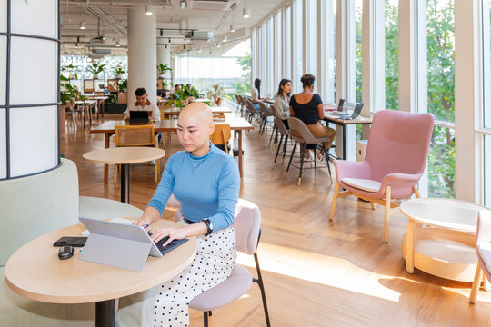 Working in a Bright Office Space With People on Laptops