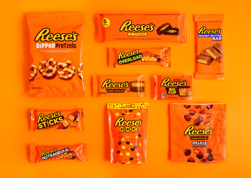 LONDON, UK - JANUARY 11, 2025: various product of Reese's pieces peanut butter and chocolate bars and snacks on orange background.
