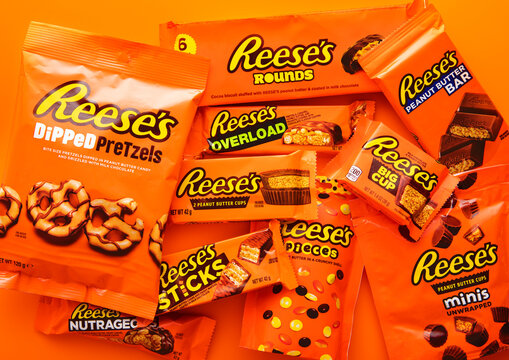 LONDON, UK - JANUARY 11, 2025: various product of Reese's pieces peanut butter and chocolate bars and snacks on orange background.