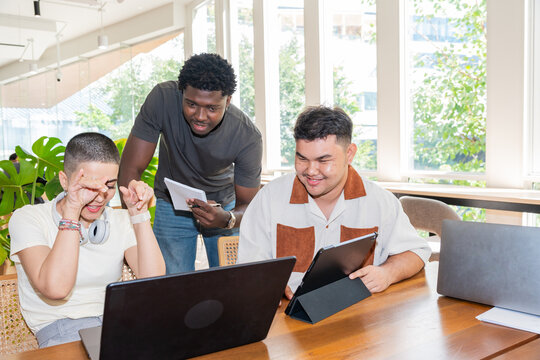 Happy Group Works Together on a Project in a Bright Office Space