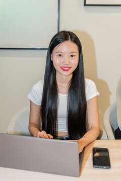 Portrait Of Young Woman Working on Laptop in Office Setting at Daytime