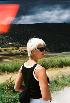 Woman Walking Along a Path in a Rural Area With Mountains