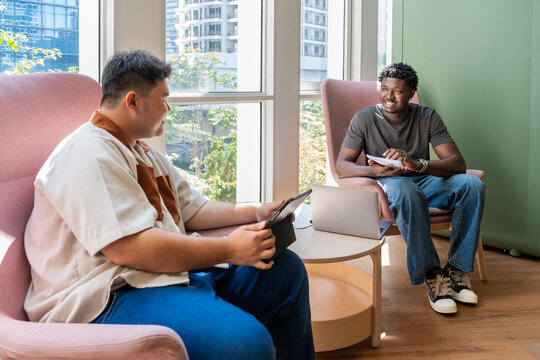 Two Men Talk and Work in a Modern Indoor Space During the Day
