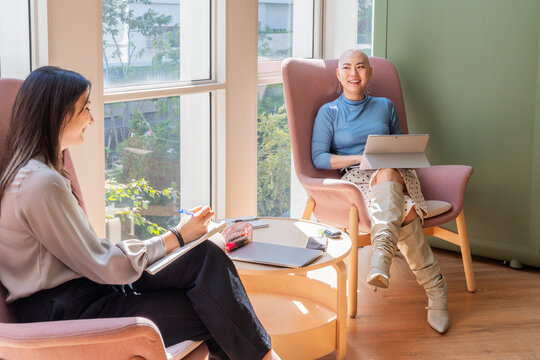 Women Engage in Conversation at a Modern Office During the Day