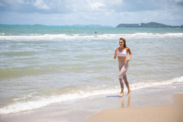 Fototapeta premium Woman running during outdoor s workout on summer beach