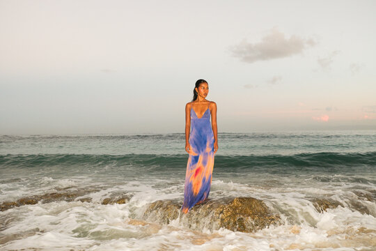Woman Standing on Rock in Ocean Waves