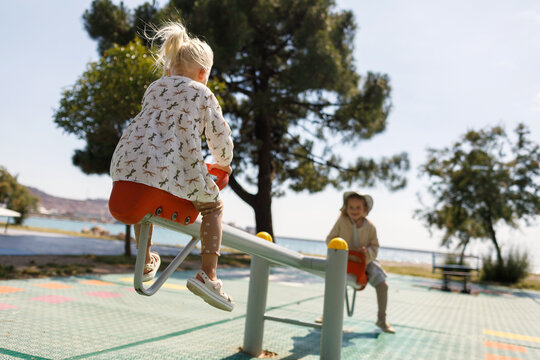 Children swinging on a seesaw on a sunny day