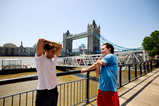 Two men exercise outdoors by the Tower Bridge