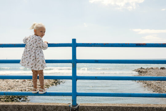 Child on the railing of a bridge over a river