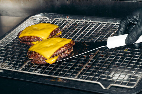 Direct flash cooking cheese burger. Fast food restaurant worker