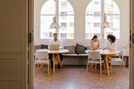 Professionals working remotely in a bright shared office space