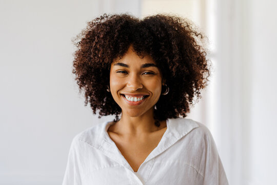 Happy woman looking at camera against white space