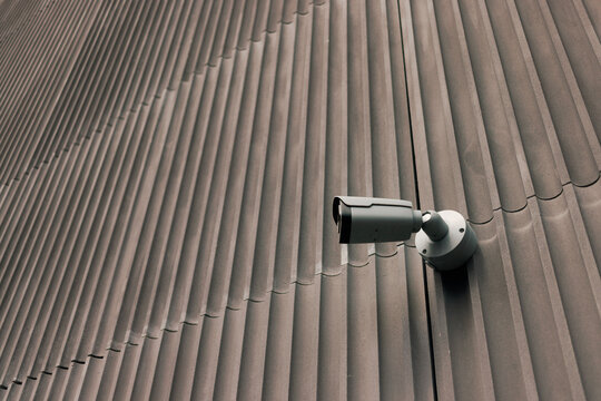 Security Camera Mounted on a Building Wall With Vertical Lines