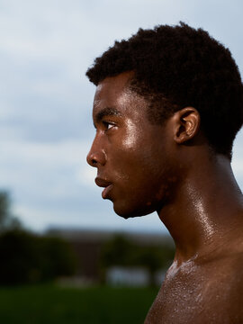 Young Man Stands Outdoors With Sweat on His Face at Sunset