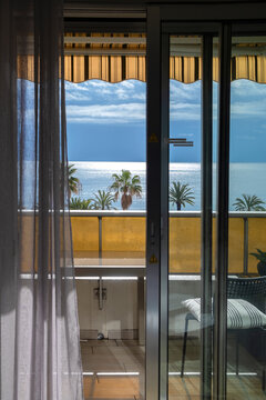Balcony view of the sea, palm trees and blue sky in Nice France