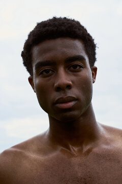 Young Man Stands Outdoors With a Focused Expression on His Face
