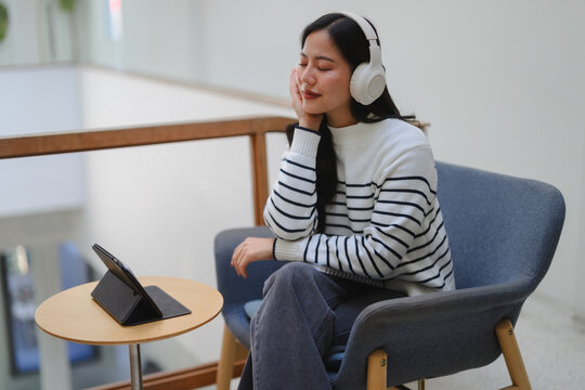 Young woman enjoying music with wireless headphones relaxing indoors
