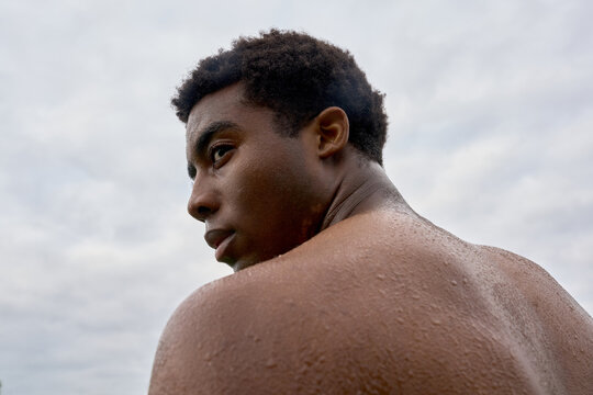 Young Man Looks Back With Water Droplets on His Skin