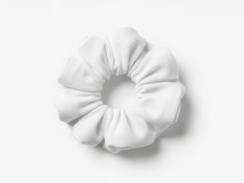 A soft and fluffy white scrunchie lying on a plain white background.