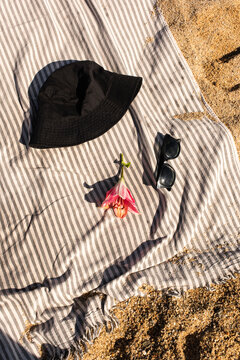A black hat, sunglasses, and a flower