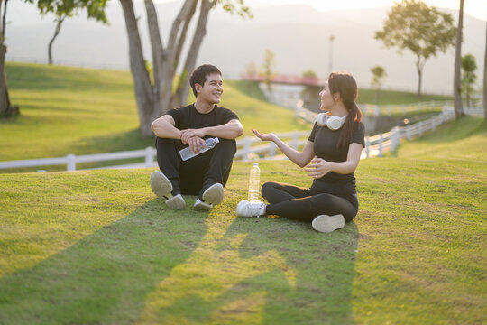 Young couple talking while relaxing on grass outdoors