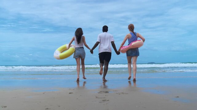Energetic millennials running joyfully along the shoreline, representing an authentic, unplugged lifestyle and the ultimate weekend getaway.