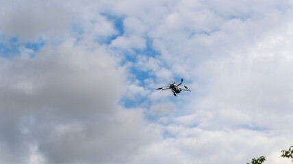 Naklejka premium Small drone flying in the sky with clouds and blue sky background