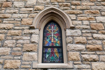 Fototapeta premium The Stained Glass Window Set in an Arched Stone Wall Facade