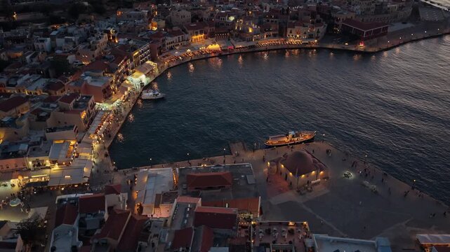 Aerial drone view of the old Venetian harbor and the domed Kucuk Hasan mosque at blue hour, Chania, Greece