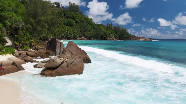 Vacation travel holidays and recreation on beach concept. Tropical beach with sea and palm taken from drone. Praslin island, Seychelles. Slow motion