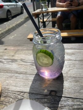 Erfrischende Holunderlimonade mit Gurke, Limette und Minze im Glas auf einem Caf&eacute;-Tisch. Sommergetr&auml;nk, Detox Water, Hydration, gesunder Lifestyle und Outdoor-Genuss.