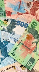 Fototapeta premium Zambian kwacha money bills in pile on table. Zambia ZMW currency cash close up